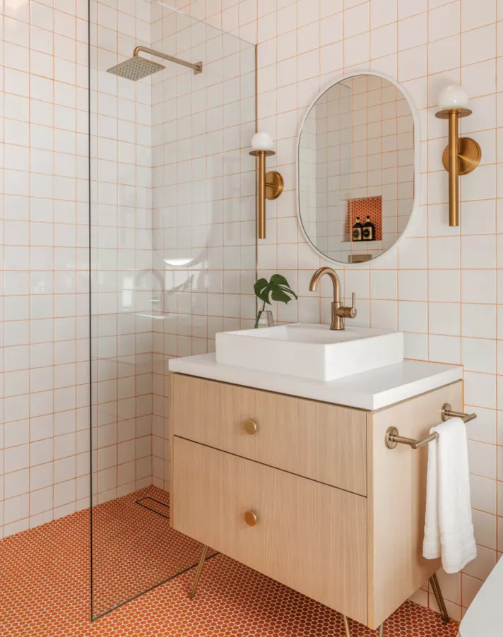 Những đường kẽ gạch (đường ron) trên tường phòng tắm không nhất thiết lúc nào cũng phải có màu trắng nhạt nhòa đơn điệu. Hãy thử dùng màu cam tươi tắn như phòng tắm này xem, bức tường trắng đã được tô điểm nhanh chóng rồi!