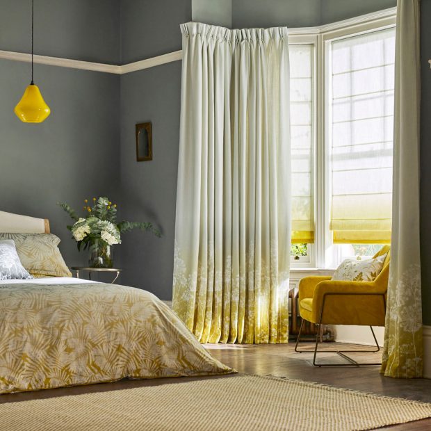 Sẽ thật tuyệt vời nếu màu sắc, hoa văn của rèm che có sự liên kết nhất định với nội thất trong phòng ngủ. Ở đây, NTK tận dụng cửa sổ lồi để thiết lập góc thư giãn xinh xinh, với rèm che kiểu Roman và rèm vải bên trong cùng tone màu vàng - trắng.