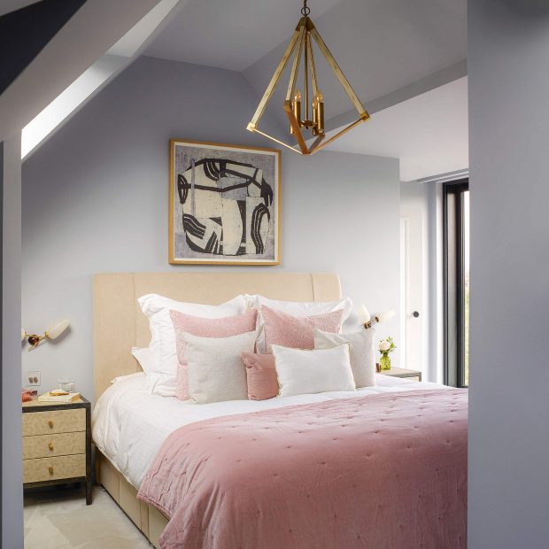Cặp đôi kết hợp tone màu xám - hồng cho phòng ngủ, thêm đèn chùm độc đáo với màu vàng đồng cho không gian cuốn hút hơn.
