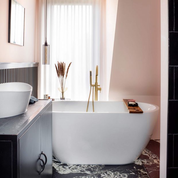 Bồn tắm, bồn rửa tay màu trắng tạo sự tương phản mạnh mẽ với sàn và tủ vanity màu đen cho vẻ đẹp cổ điển. 