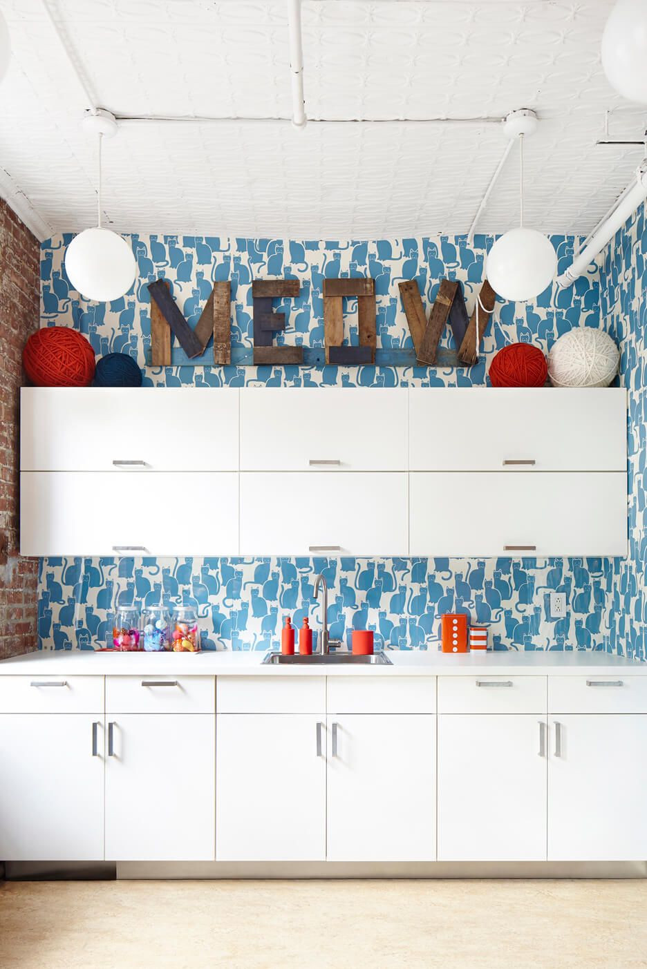 Ý tưởng dành cho người yêu thích DIY: Sử dụng giấy dán tường cho một phần tường bếp, vị trí trên nóc tủ sẽ thể hiện chủ đề trang trí ( mèo, mùa xuân, cây cối,...).