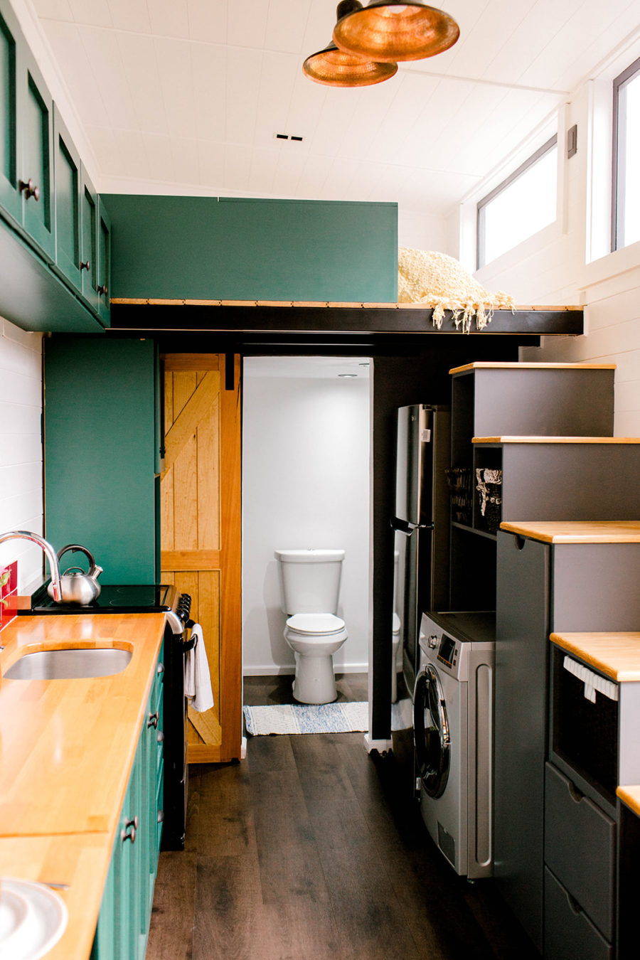Quay trở lại với tầng dưới, bạn sẽ thấy ẩn đằng sau cánh cửa trượt kiểu cửa chuồng bằng gỗ là phòng vệ sinh và phòng tắm nhỏ gọn.