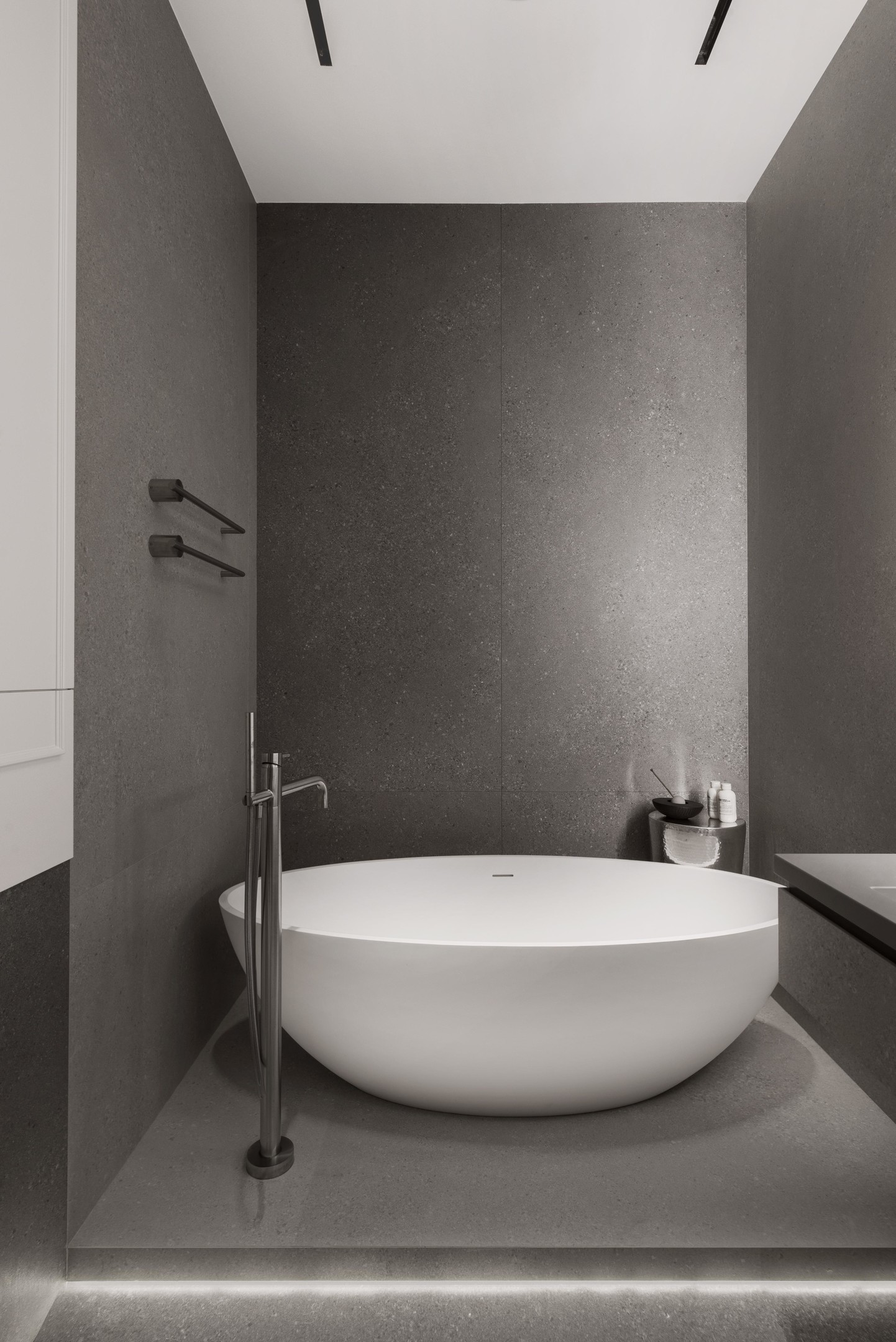 Phòng tắm này có gì? Một chiếc bồn tắm bằng sứ trắng với hình tròn duyên dáng, vòi nước, chiếc bàn phụ nhỏ nhắn và 2 thanh treo khăn tắm gắn tường. Hoàn hảo cho những không gian 'khiêm tốn' về diện tích!
