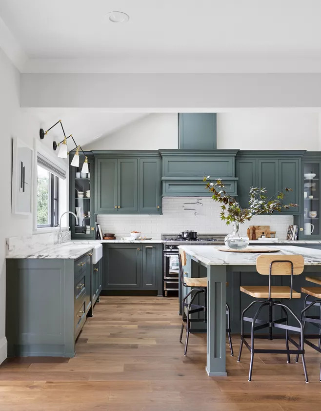 Phòng bếp rộng rãi với thiết kế kiểu chữ L cùng đảo bếp tiện nghi tại khu vực trung tâm. Màu xanh xám của hệ thống tủ lưu trữ kết hợp với mặt bàn đá cẩm thạch tôn lên vẻ đẹp sang trọng cho phòng bếp.