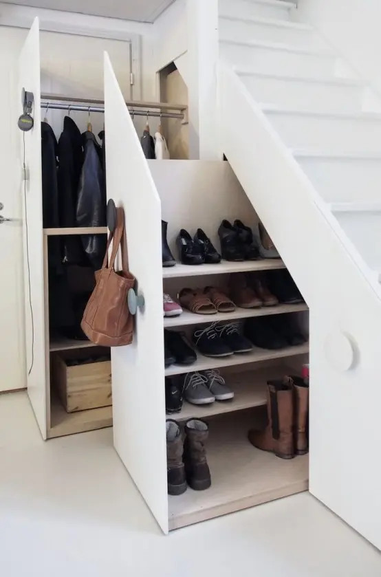 Khi thiết kế gầm cầu thang, bạn hãy bổ sung những chiếc tủ bí mật với rất nhiều kệ đựng giày dép và áo khoác cho các thành viên trong gia đình để không gian luôn gọn gàng, ngăn nắp nhé!
