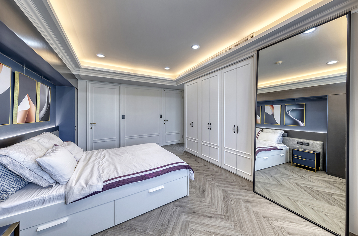 Một tấm gương cỡ lớn với kích thước từ trần đến sàn góp phần nhân rộng cả không gian và ánh sáng, khiến phòng ngủ đã rộng càng thêm thoáng đãng.