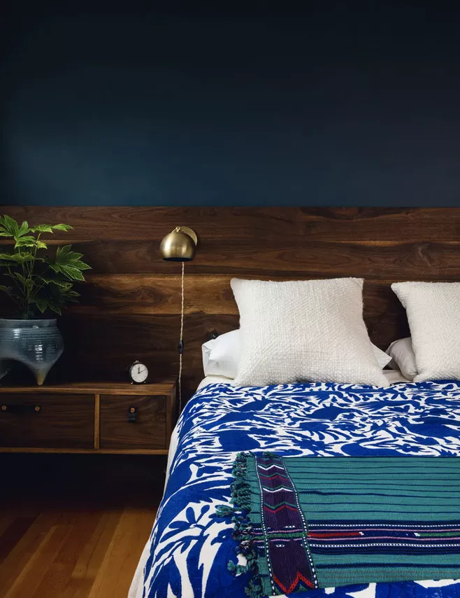 Khi thiết kế phòng ngủ, hầu hết chúng ta sẽ chọn mua 1 chiếc táp đầu giường riêng biệt. Nhưng hãy nhìn phòng ngủ này, chủ nhân của nó đã tiết kiệm không gian bằng cách chọn táp gắn liền với đầu giường, cùng vật liệu/tone màu gỗ trầm ấm đẹp mắt.