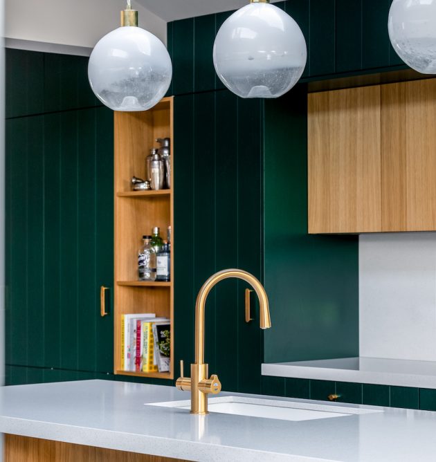Khu vực bếp và hệ thống tủ lưu trữ sử dụng gam màu xanh ngọc lục bảo làm chủ đạo, với thiết kế cao kịch trần.