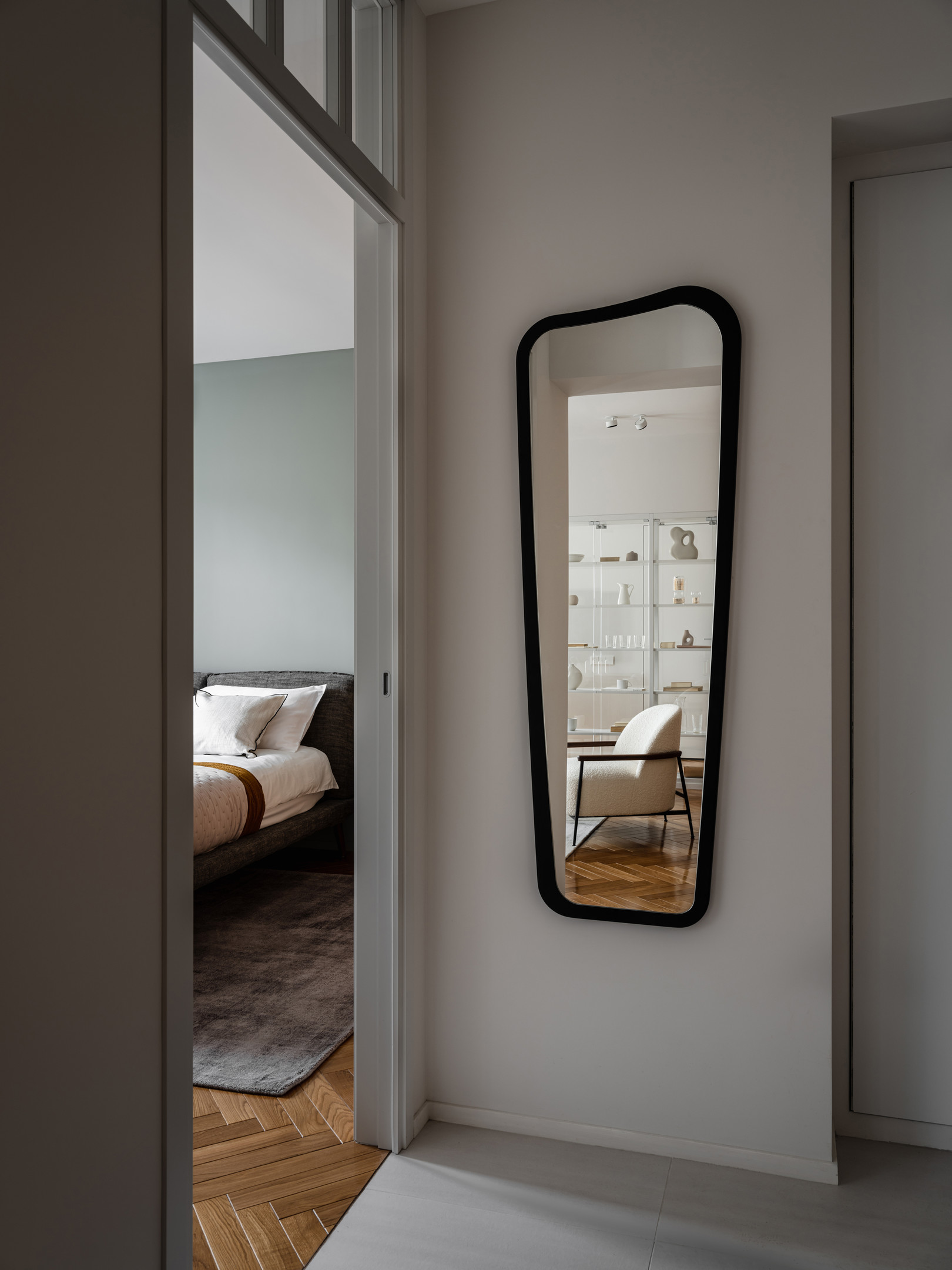 Phía trước cửa ra vào phòng ngủ bố mẹ là tấm gương cỡ lớn với kiểu dáng mới lạ ốp trên tường nhằm phản chiếu hình ảnh phòng khách và chiếc kệ trong suốt tuyệt đẹp.