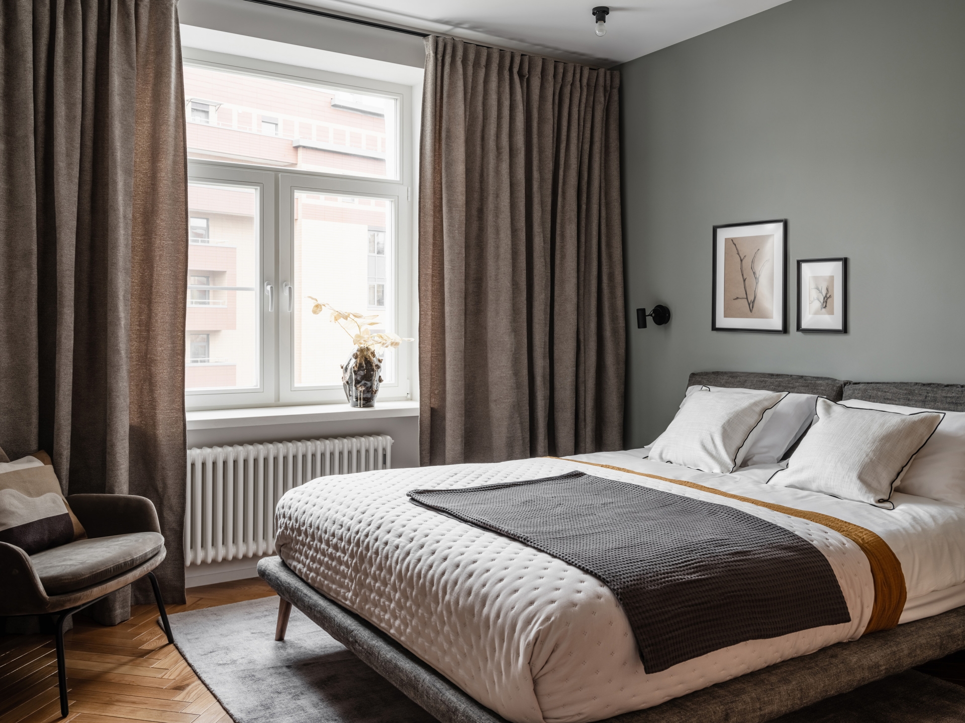 Phòng ngủ chính của bố mẹ sử dụng tường sơn màu xám ấm, rèm che dày dặn tạo sự riêng tư, bộ giường nệm chất lượng cao cho sự êm ái tuyệt đối.