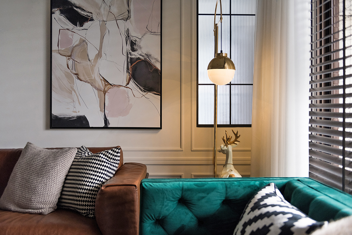 Khoảng trống ở góc tường, giữa hai chiếc sofa là chiếc đèn sàn dáng cao với bóng đèn hình quả cầu tròn, thân đèn làm bằng chất liệu kim loại mạ vàng đồng sang trọng, ấm áp.