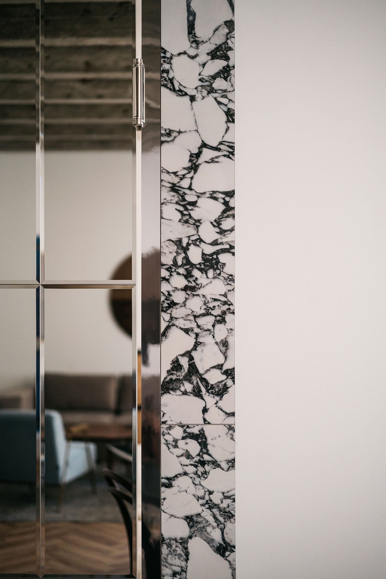 Cánh cửa gương gia công tỉ mỉ, sắc sảo theo thiết kế riêng và đặt làm theo yêu cầu, bao quanh tường ốp đá cẩm thạch làm 'viền khung' sang chảnh.