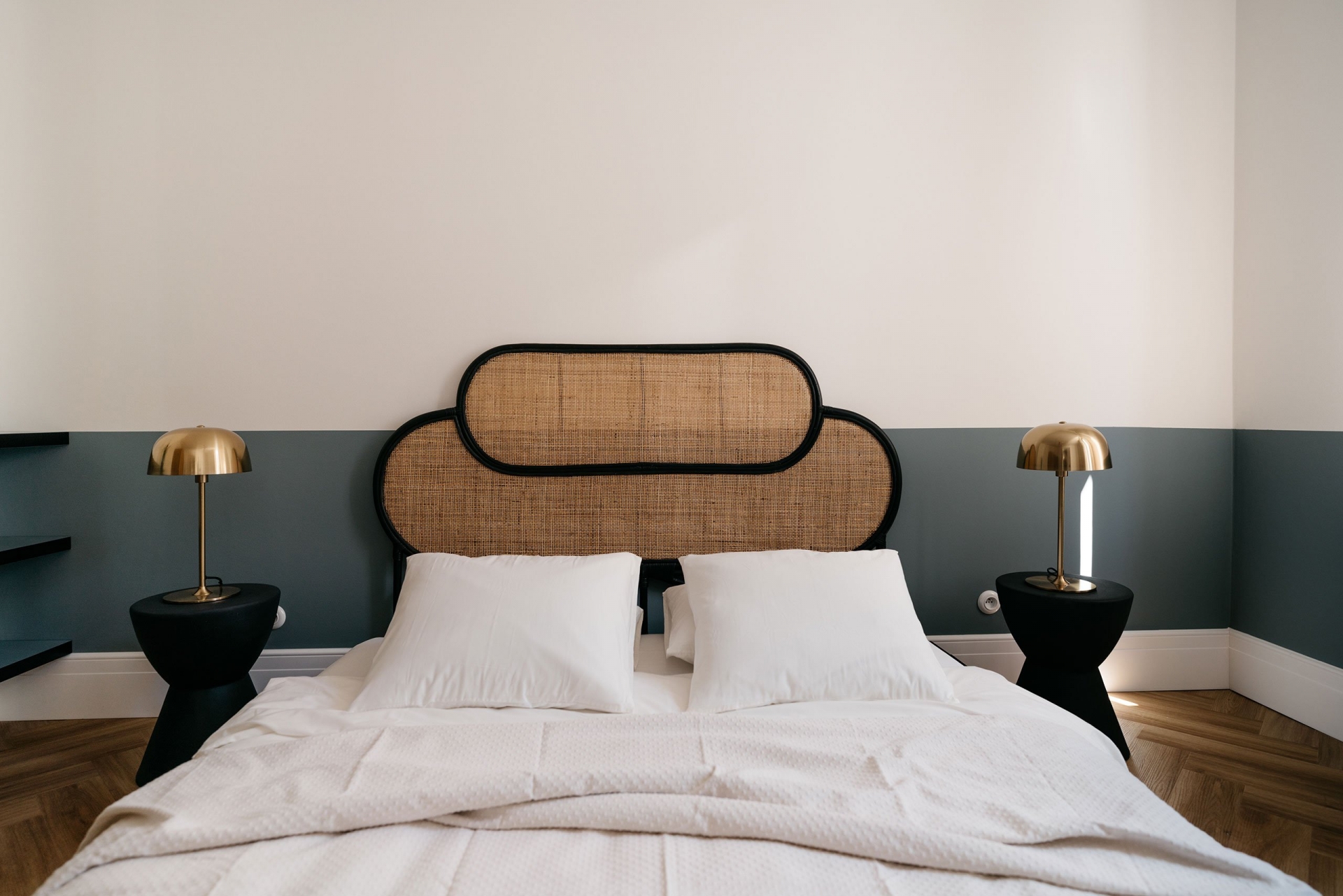 Phòng ngủ sử dụng gam màu trắng và xanh cổ vịt làm điểm nhấn trang trí, nổi bật là đầu giường bằng mây tre đan mộc mạc. Bộ táp đầu giường và đèn bàn đặt đối xứng cho phòng ngủ cái nhìn cân đối.