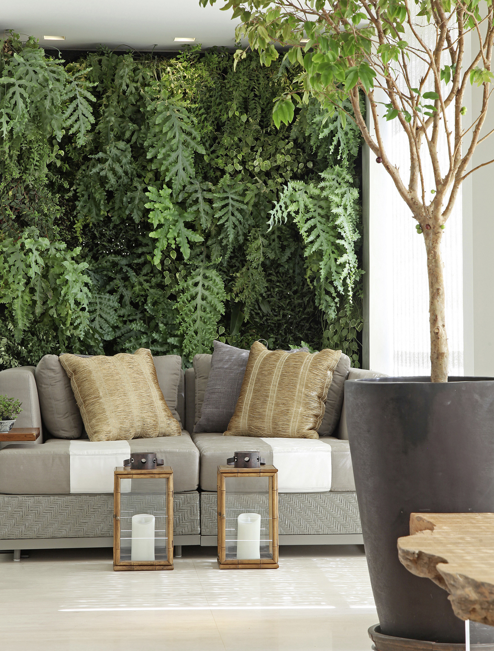 Bước vào phòng khách trong căn hộ này mà chúng ta cảm giác như lạc vào một khu rừng với cây cối tươi xanh, không chỉ là cây trồng trong chậu mà còn cả trên bức tường sống động.
