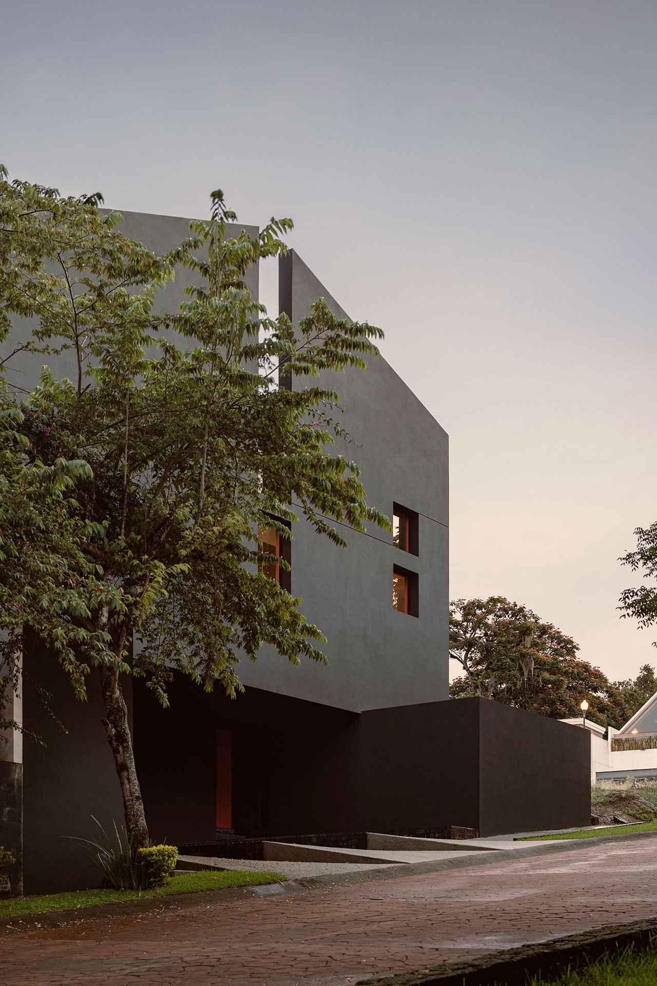 Ngôi nhà này được ví như là một công trình nguyên khối xuyên qua bởi một cấu trúc bất thường với các khung cửa sổ đỏ trên phông nền đen. 
