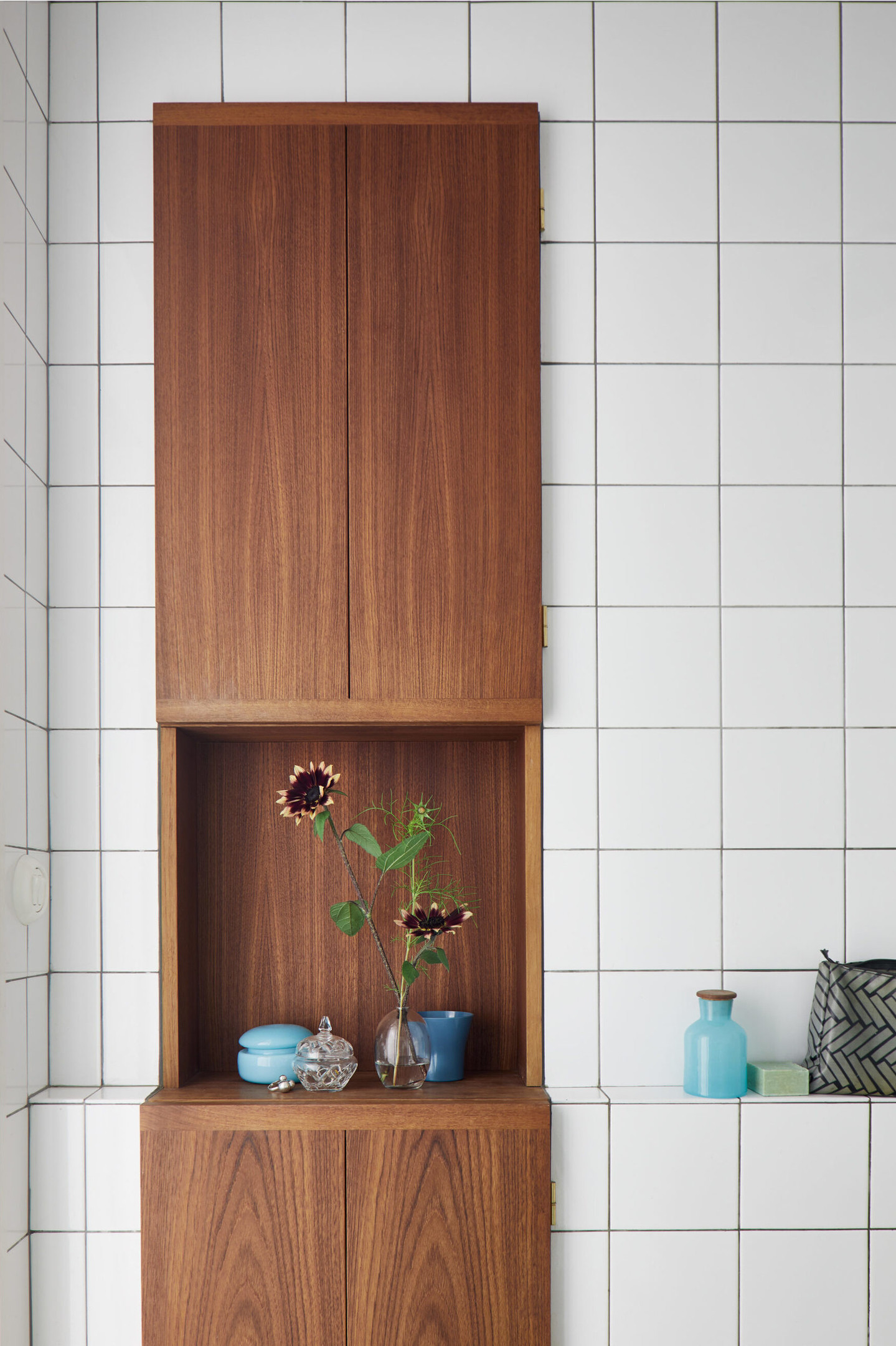 Lựa chọn hệ tủ lưu trữ bằng gỗ ấm áp giúp không gian căn phòng ốp gạch mosaic vuông màu trắng trở nên nổi bật và có điểm nhấn hơn hẳn. Đây cũng là giải pháp thiết kế khéo léo mà bạn có thể tham khảo.