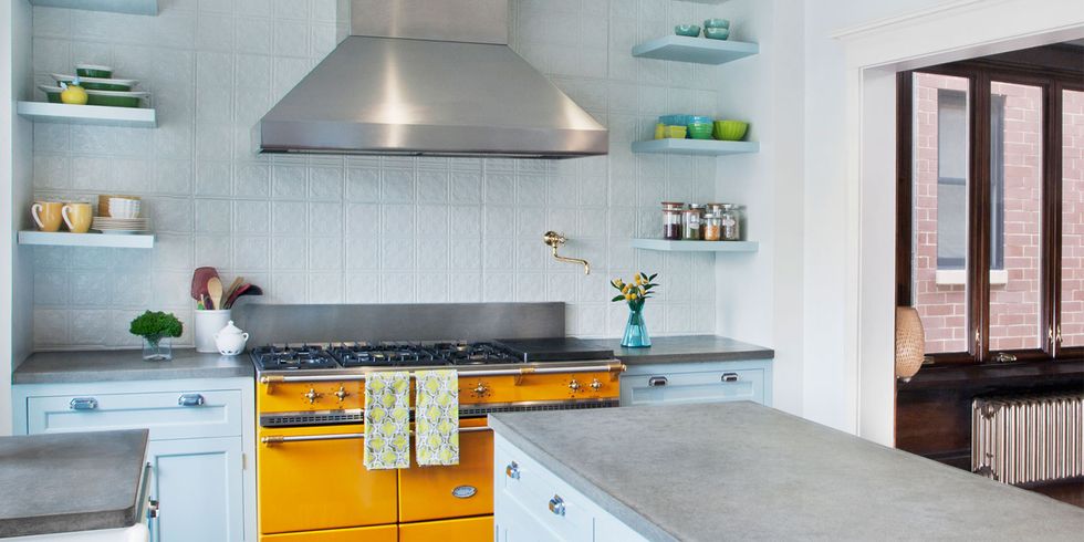 Những chiếc kệ mở gắn tường và hệ thống tủ bếp dưới màu xanh pastel dịu nhẹ trở thành phông nền hoàn hảo để sắc vàng đậm như những bông hoa cúc vạn thọ ở khu vực trung tâm bếp nấu sáng bừng hơn bao giờ hết!