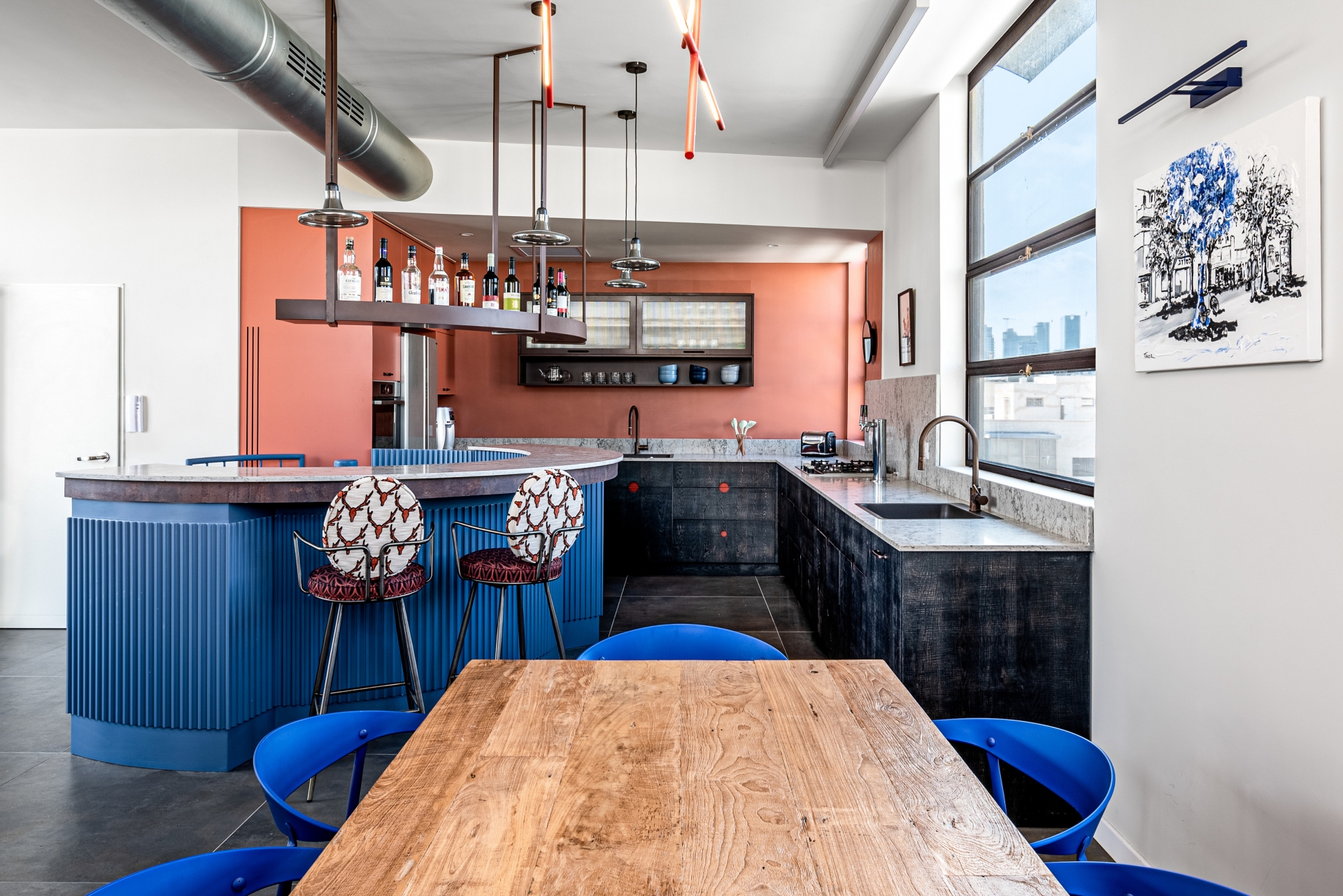 Khu vực nấu nướng cực kỳ ấn tượng với bảng màu cam gạch ấm áp, xám đen sang chảnh, thêm cả phần quầy bar mở rộng với đường cong mềm mại cùng tone màu xanh lam kết nối với nội thất tầng 1 cho cái nhìn hài hòa.