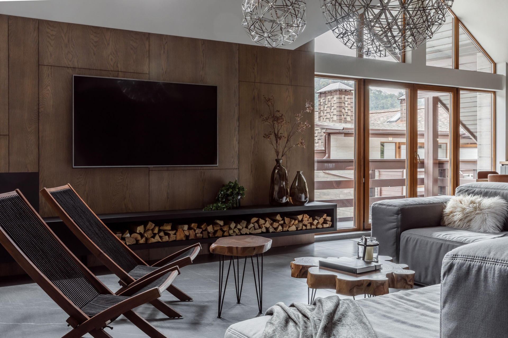 Không gian phòng khách trên căn hộ áp mái thu hút người nhìn bởi vẻ đẹp cổ điển pha lẫn hiện đại, với sự góp mặt của nội thất gỗ bền vững, thân thiện với môi trường cùng tone màu xám chẳng bao giờ lo lỗi mốt.