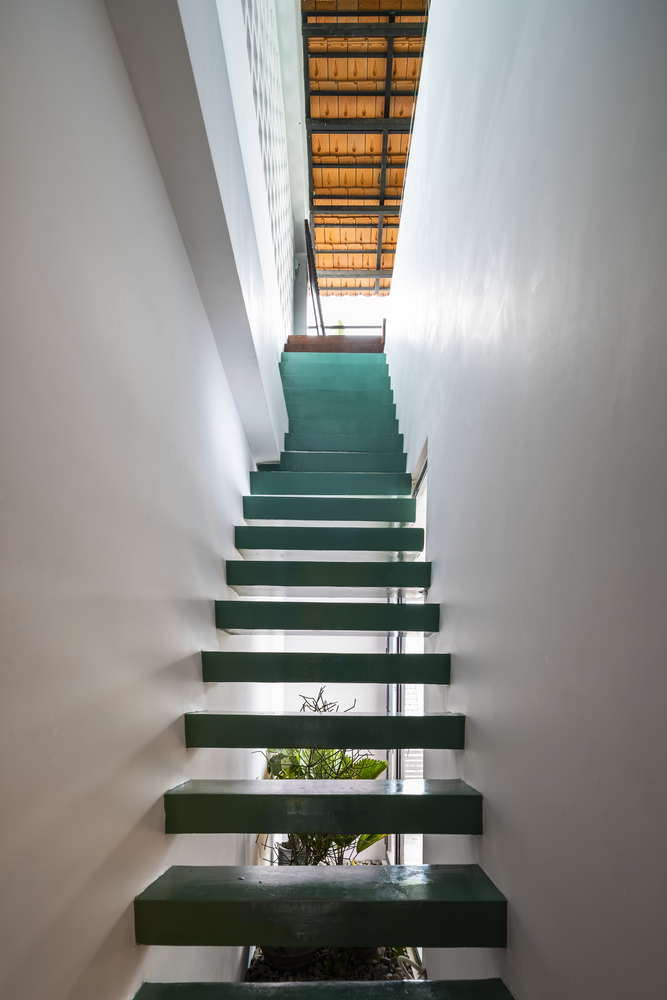 Trục cầu thang được bố trí về một phía ở nửa sau của ngôi nhà, sau đó đến nửa trước ở tầng 2, với tone màu xanh lá tạo sự kết nối với mặt tiền.