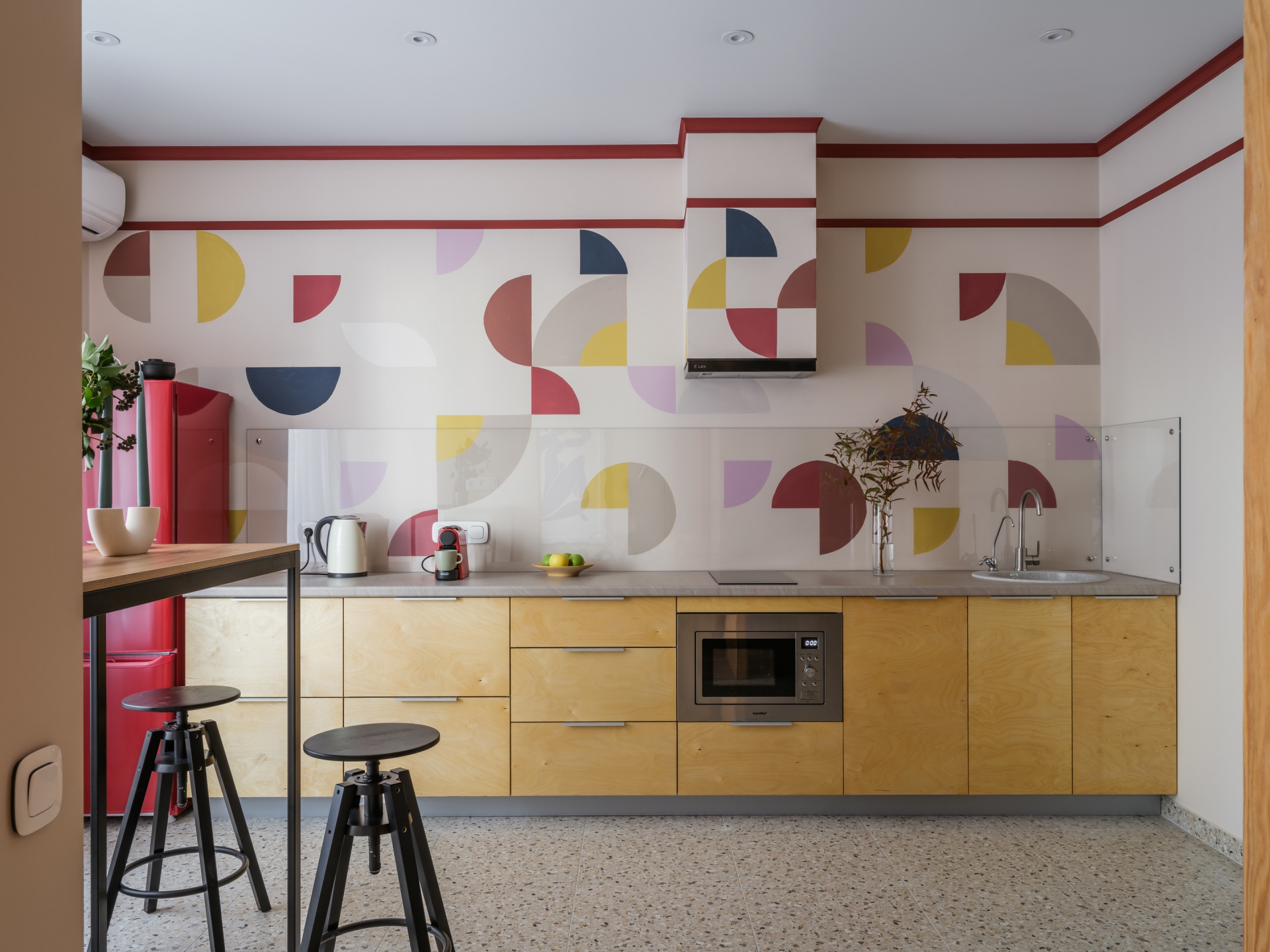 Phòng bếp xinh xắn và trẻ trung với họa tiết hình học trang trí tường cũng như khu vực backsplash đầy màu sắc. Và hẳn bạn sẽ cảm thấy thú vị khi xung quanh hệ thống hút mùi cũng được 'khoác áo mới' đúng không nào?