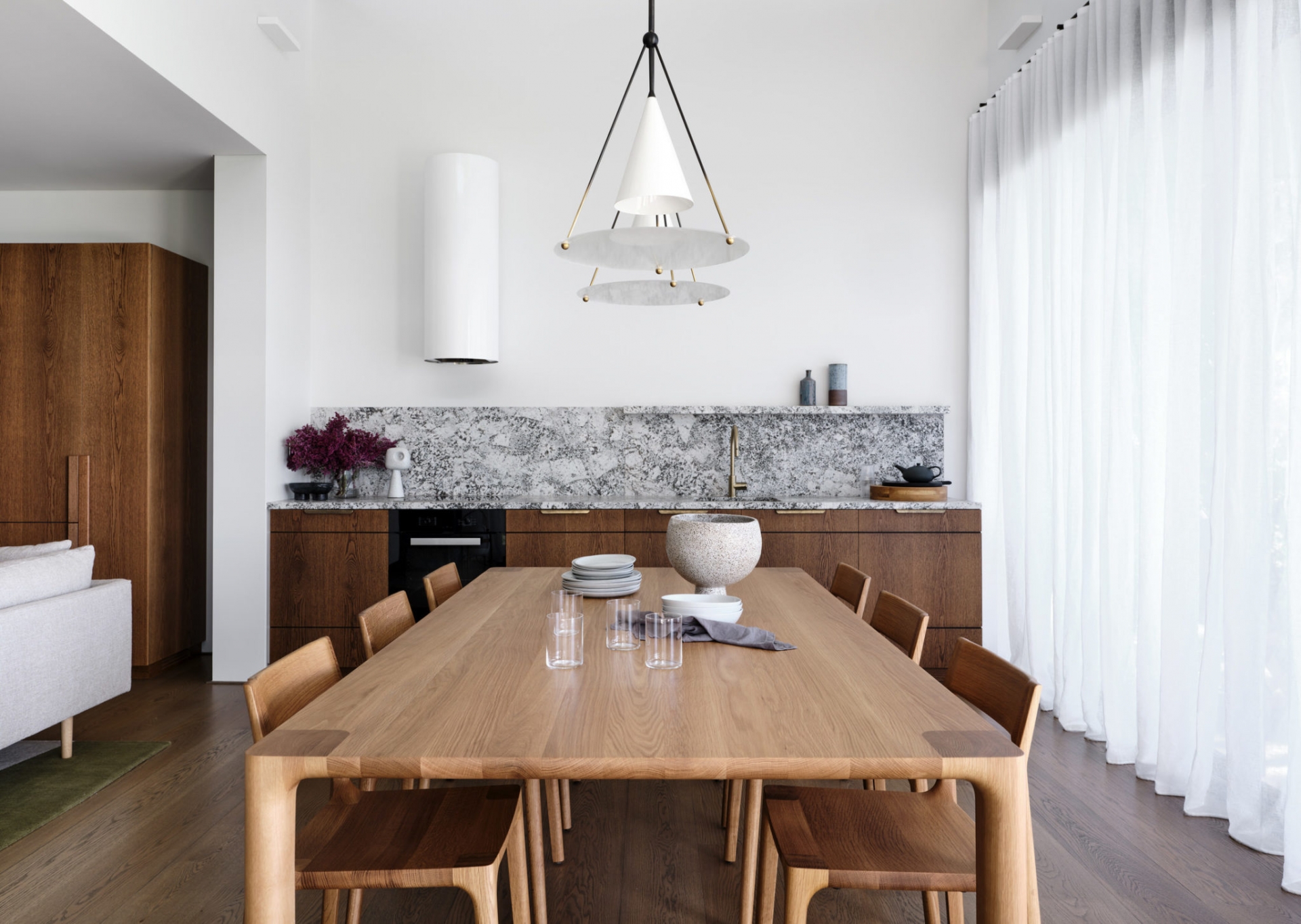 Đối với những phòng bếp nhỏ, thiết kế mở liên thông với phòng khách và phòng ăn như trong căn hộ này thì việc lựa chọn máy hút mùi tiệp màu với nền tường phía sau sẽ giúp không gian trông rộng rãi và sạch sẽ hơn.