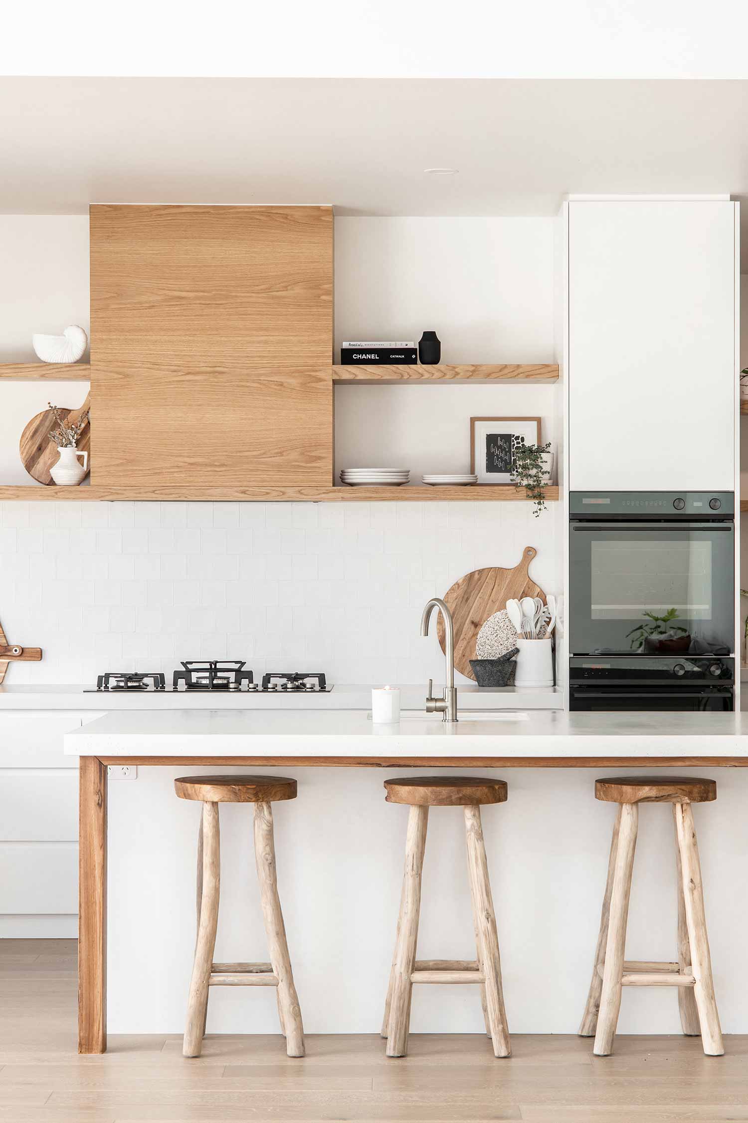 Những món nội thất và phụ kiện bằng vật liệu gỗ sẽ giúp bạn bổ sung cảm giác ấm áp, gần gũi cho phòng bếp toàn sắc trắng tinh khôi. 