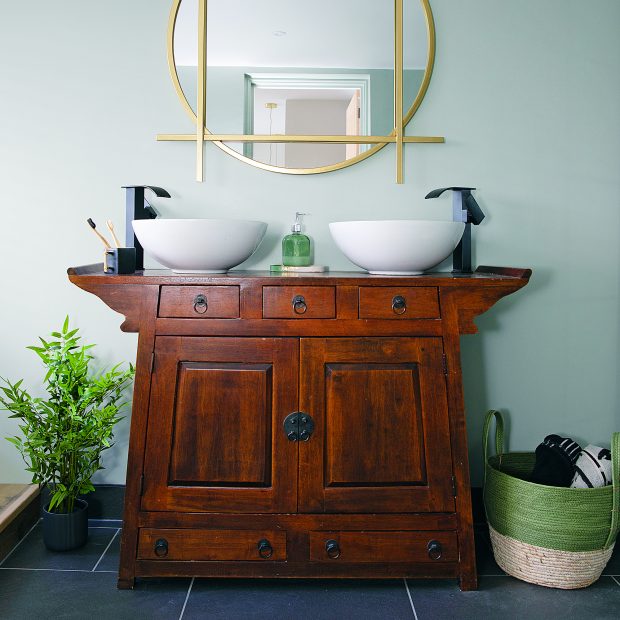 Một chiếc tủ gỗ nguyên khối đẹp đẽ đã qua sử dụng được nâng cấp để tạo ra ý tưởng lưu trữ độc đáo trong phòng tắm. 