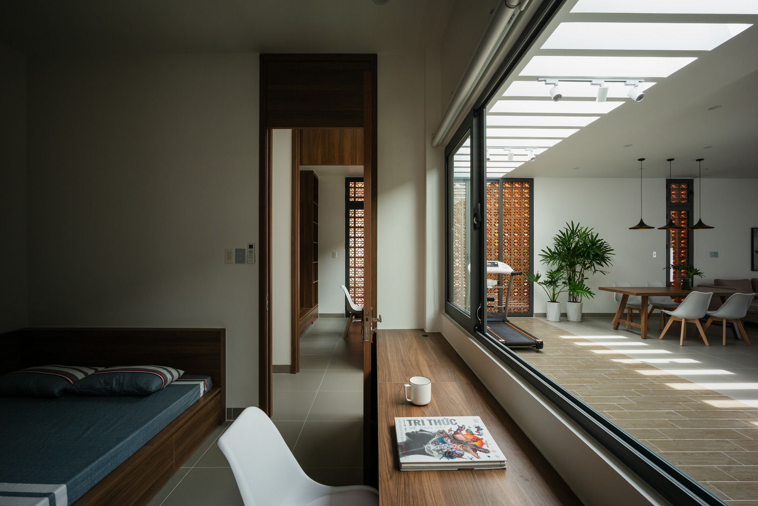 Phòng ngủ sử dụng cửa kính trượt trong suốt để có thể đón nhận ánh sáng từ không gian sinh hoạt chung và tạo cảm giác ngôi nhà thoáng đãng hơn.