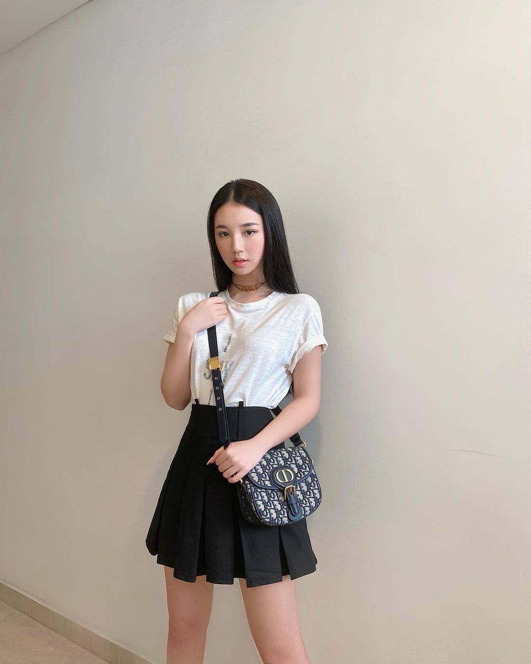 Chân váy xếp ly màu đen trơn kết hợp với áo phông trắng là combo đơn giản nhưng vô cùng hiệu quả mà các bạn gái có thể học tập cho thời trang dạo phố của mình.